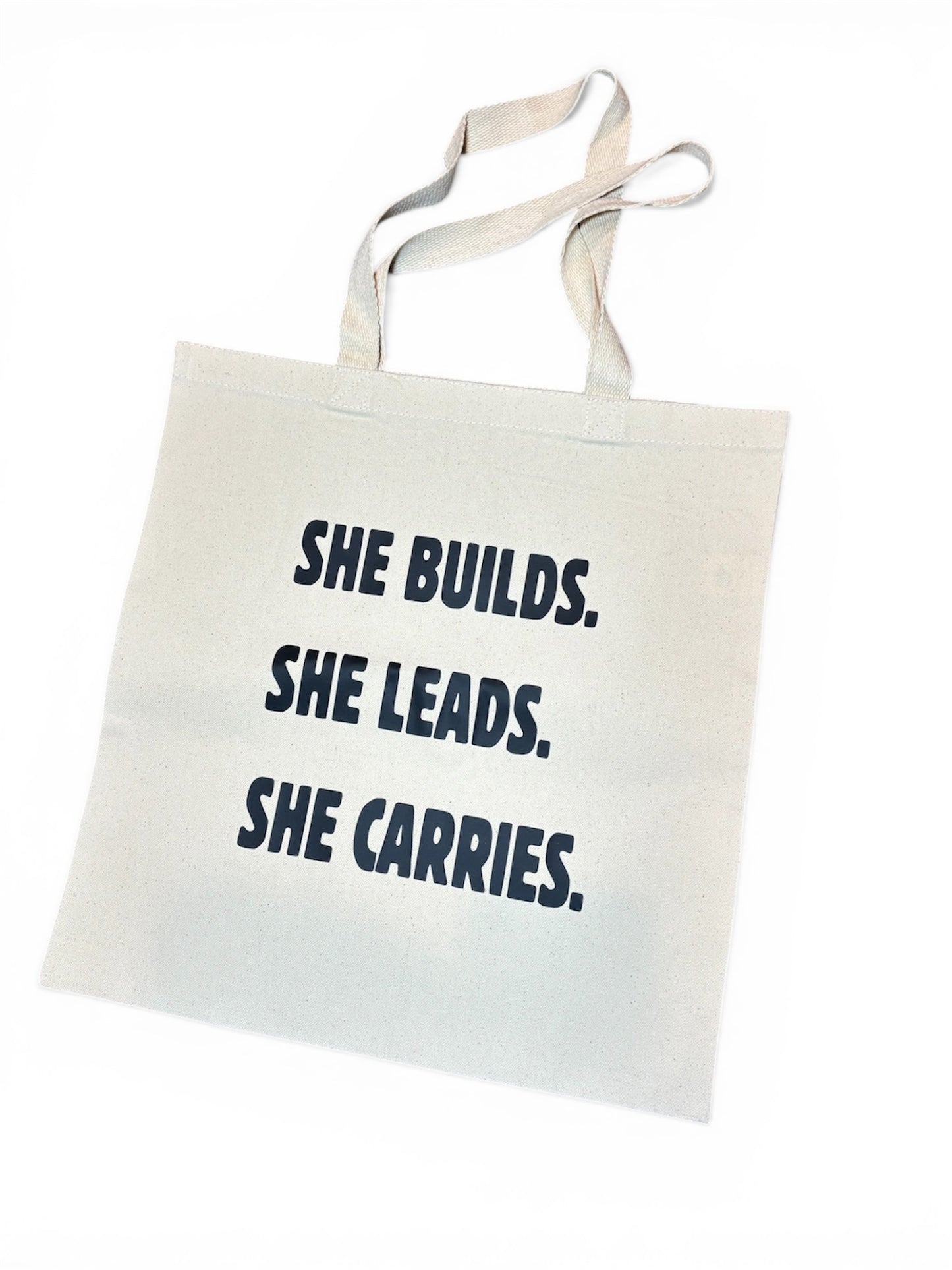 “She builds.she leads.she carries” Tote