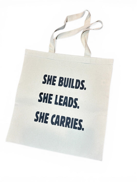 “She builds.she leads.she carries” Tote